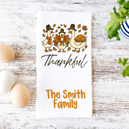 A white towel with a Thanksgiving-themed design, featuring three cartoon ducks and a turkey, along with the text "Thankful" and "The Smith Family".